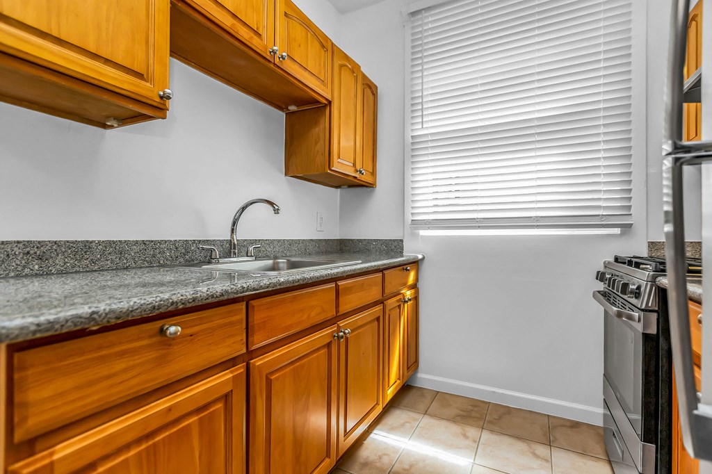 A kitchen with wooden cabinets and a granite countertop.