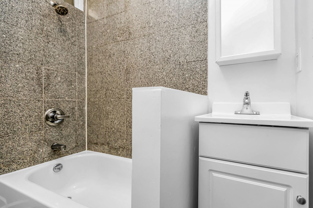 A white bathroom with a tub and sink.