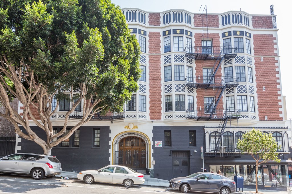 A building with a red brick facade and a balcony with a fire escape.