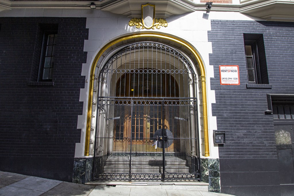 A black and white building with a gold arched entrance and a sign that says "MENENSOR".