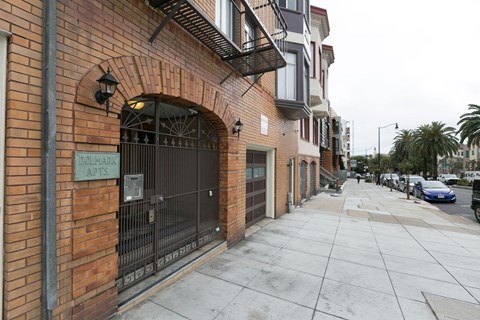 A brick building with a sign that says "Dolphin Apartments".
