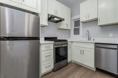 A kitchen with a stainless steel refrigerator, stove, and oven.