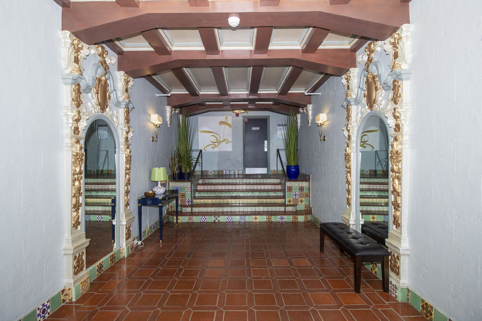 A hallway with a bench and a doorway.
