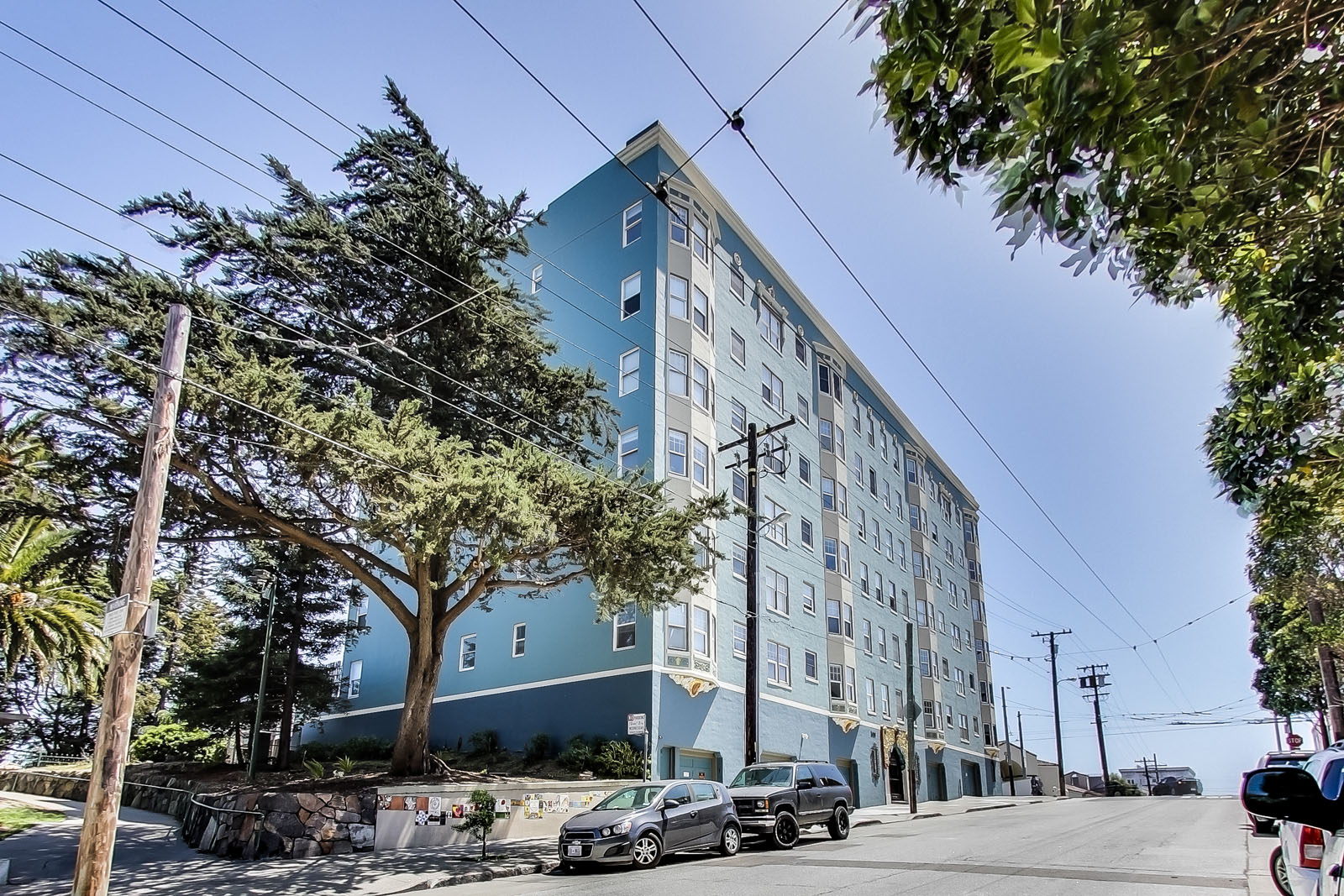 A blue building with a tree in front of it.