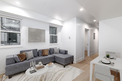A living room with a grey couch and a white table.