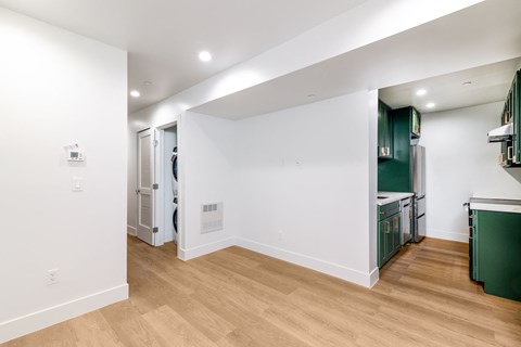 A kitchen with green cabinets and a white wall.