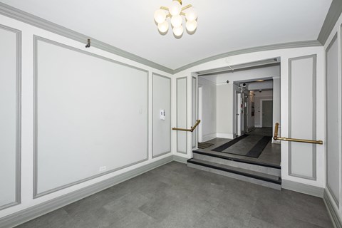 A hallway with a light on the ceiling and a door at the end.