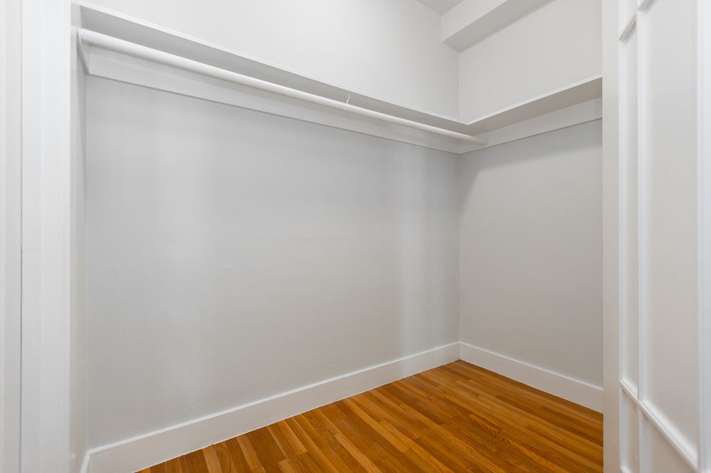 a empty room with white walls and wood floors