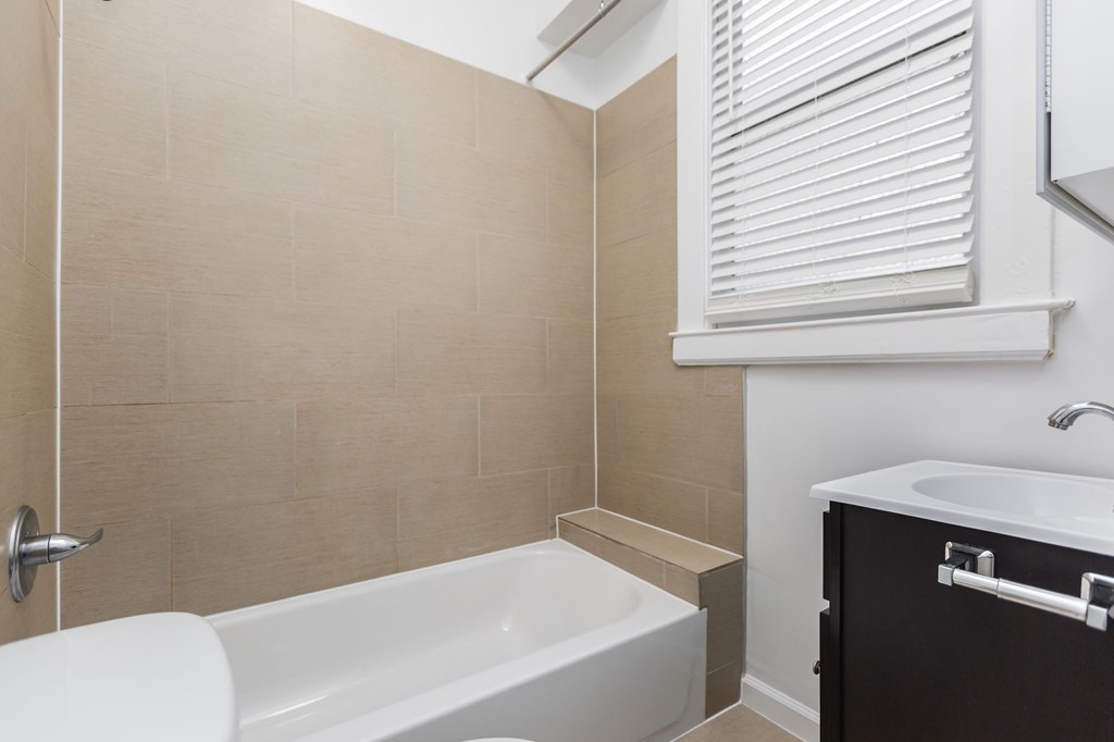 a bathroom with a tub and a sink and a window
