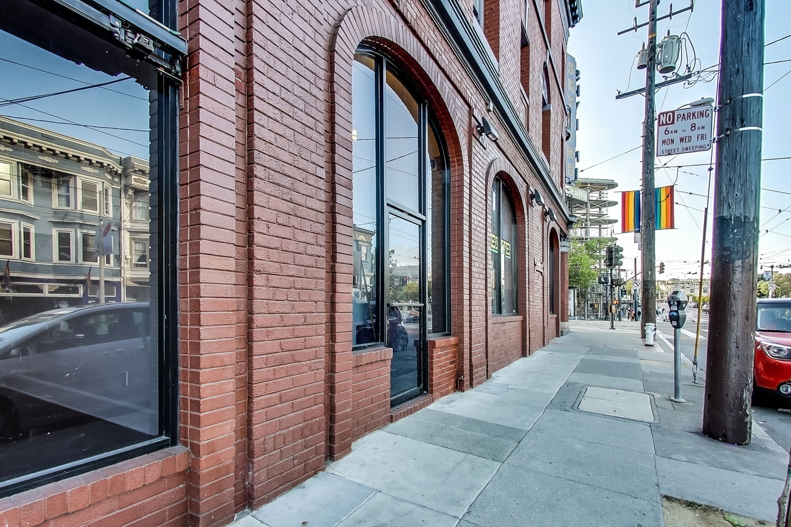 A red brick building with a sign that says "NO PARKING" on the sidewalk.