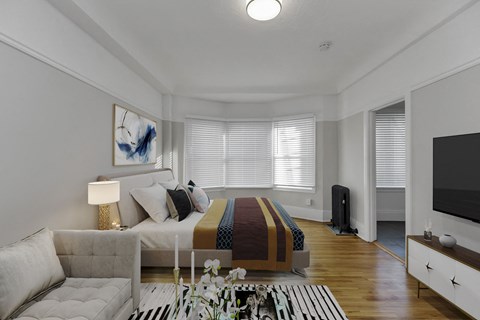 A modern bedroom with a large bed and a television.