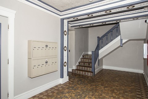 A staircase with a blue railing and a brown tiled floor.