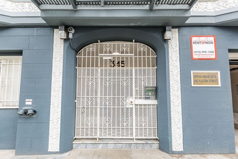 A blue building with a gate and a sign that says RentSFnow.
