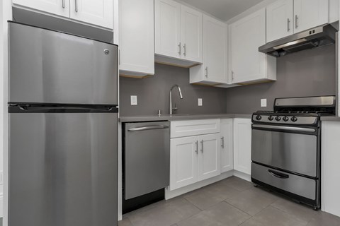 A modern kitchen with a stainless steel refrigerator and oven.