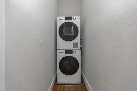 Two washing machines in a narrow laundry room.