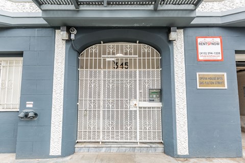 A blue building with a gate and a sign that says RentSFnow.