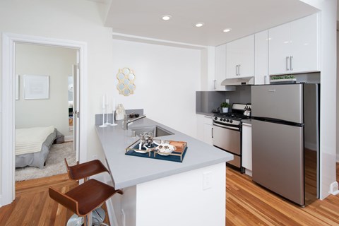 A modern kitchen with a refrigerator, oven, and sink.