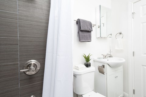 A white toilet sits next to a white sink in a bathroom.