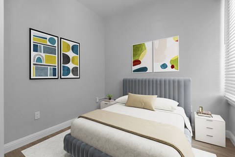 A bedroom with a bed, nightstand, and two paintings on the wall.