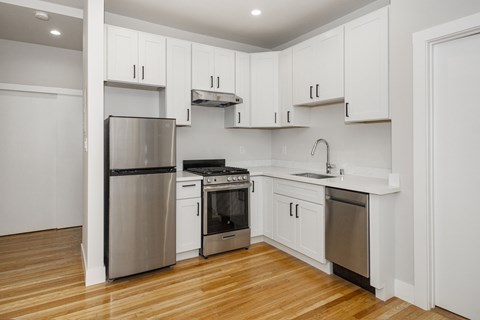 A kitchen with white cabinets and stainless steel appliances.