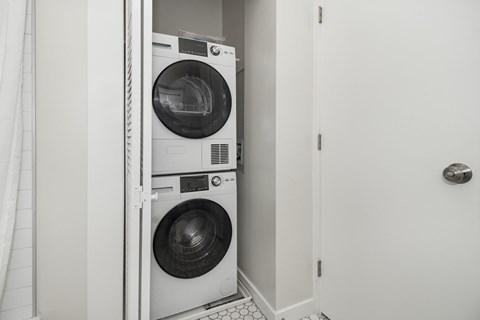 A white washing machine and dryer in a small laundry room.