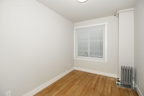 A room with a window and a radiator on the floor.
