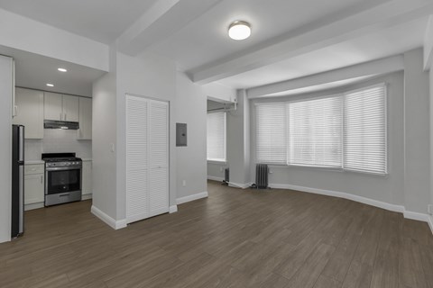 A spacious kitchen with wooden floors and white walls.