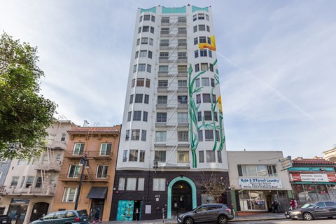 A tall building with a mural of a tree on it.