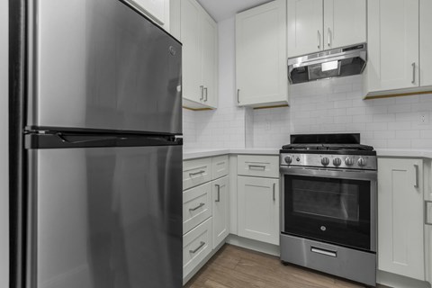 A modern kitchen with a stainless steel refrigerator and a stove top oven.