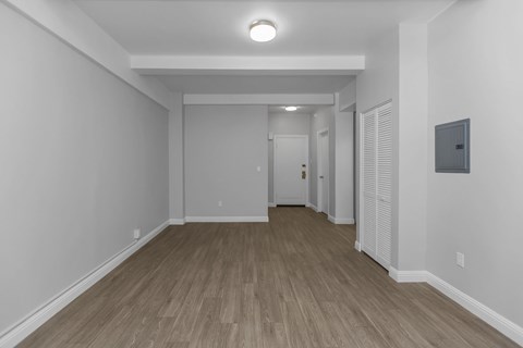 A long hallway with wood floors and white walls.