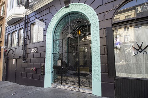 A black building with a turquoise arched doorway.