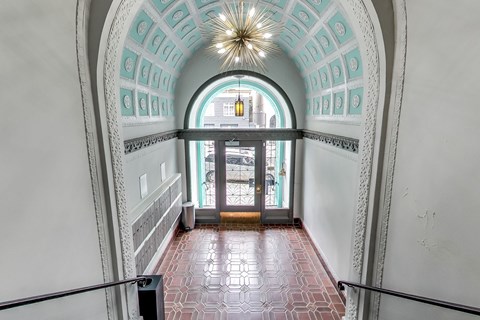 A hallway with a red tiled floor and white walls.