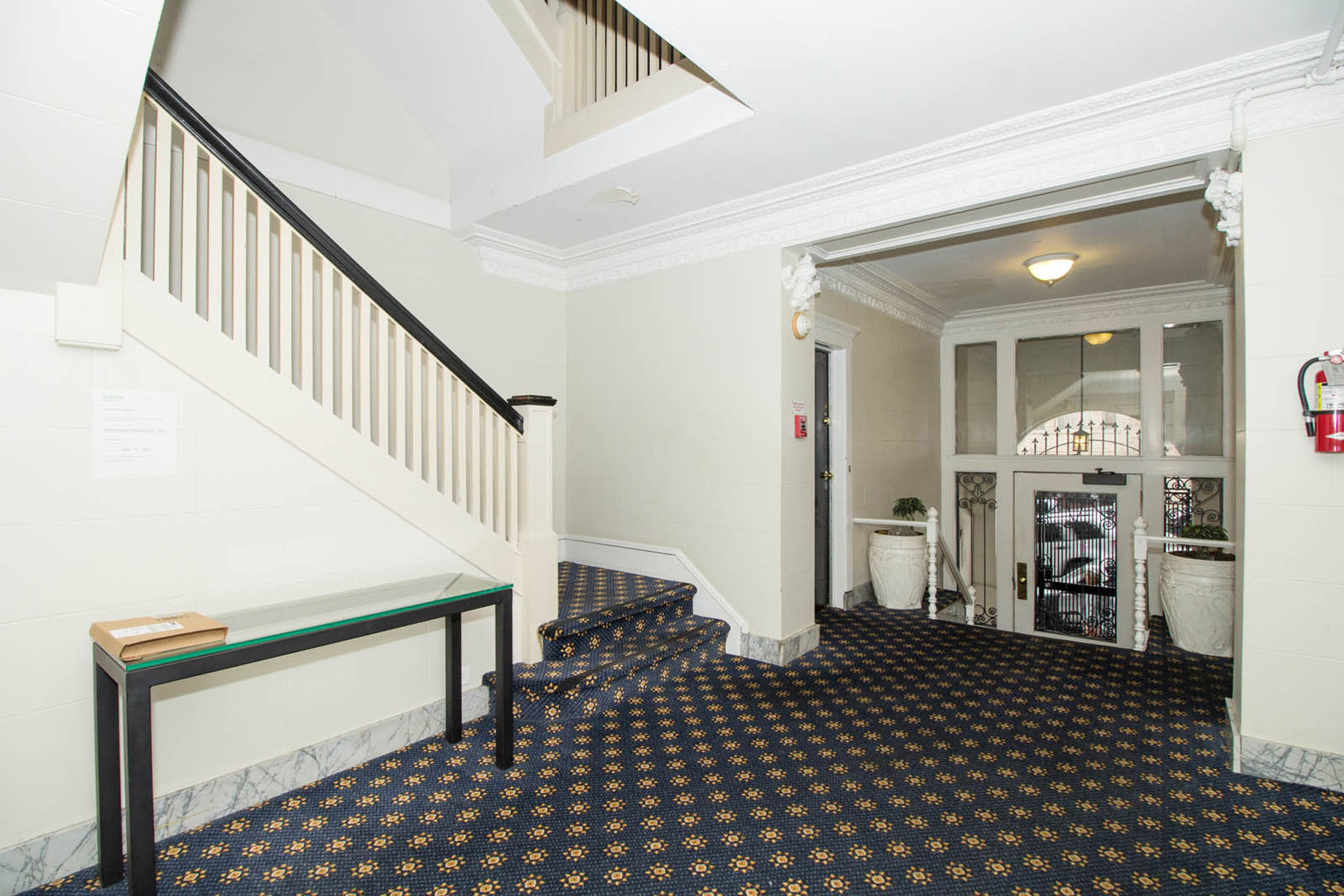 A hallway with a black and gold floor and white walls.