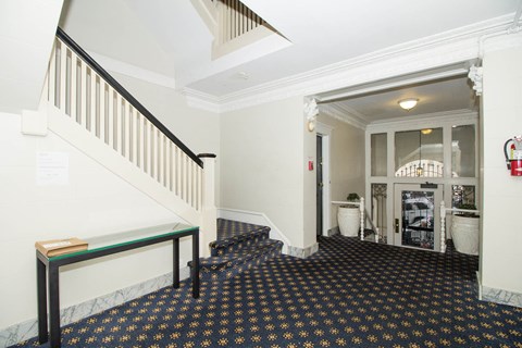 A hallway with a black and gold floor and white walls.