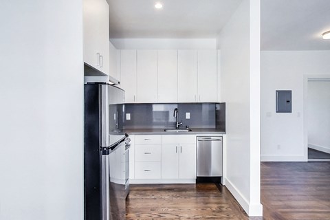 A modern kitchen with white cabinets and stainless steel appliances.