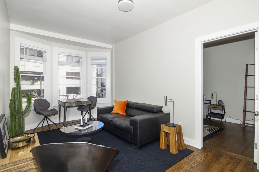 A living room with a black couch and a coffee table.