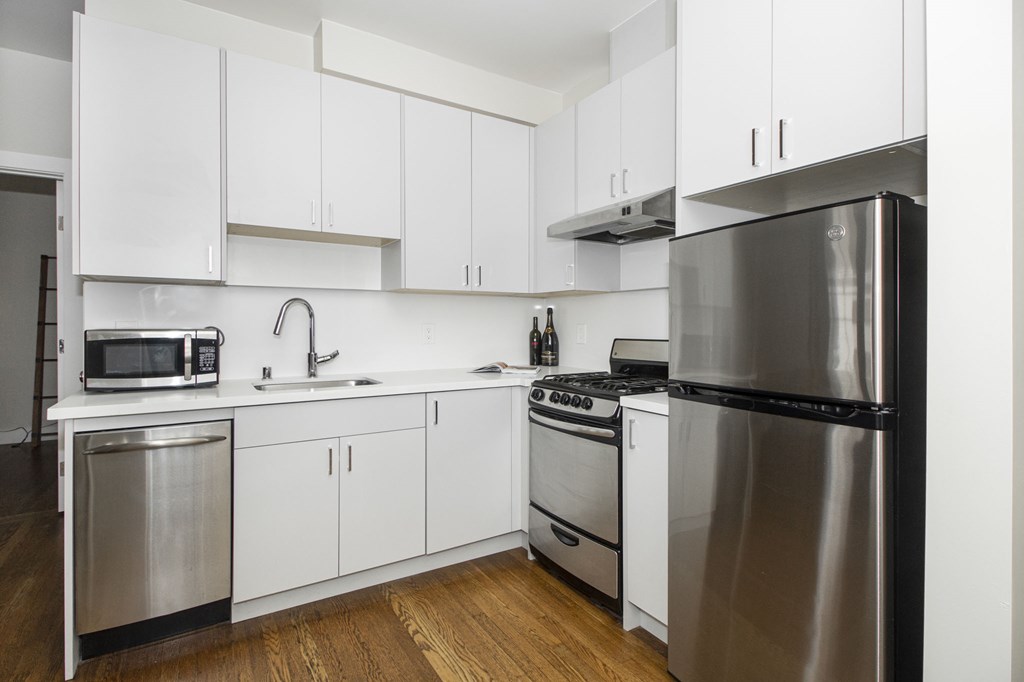 A modern kitchen with stainless steel appliances and white cabinets.