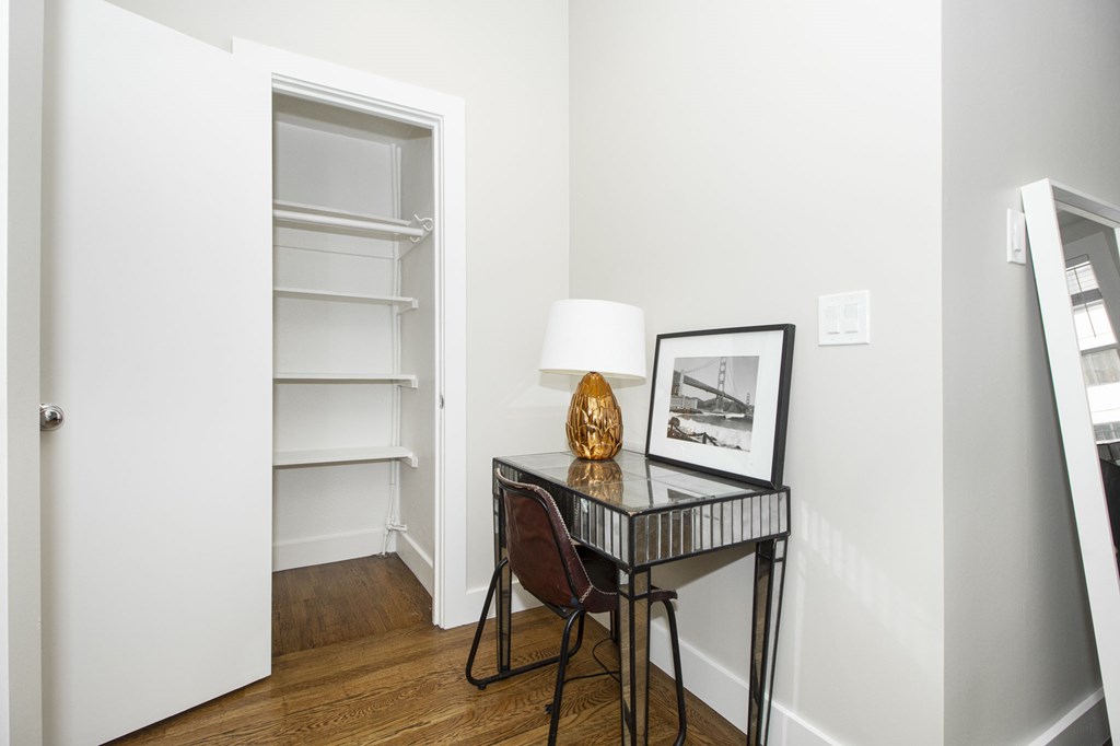 A table with a lamp and a picture frame on it.