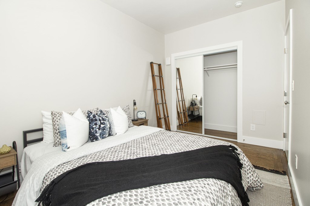 A bedroom with a bed covered in a black and white comforter.