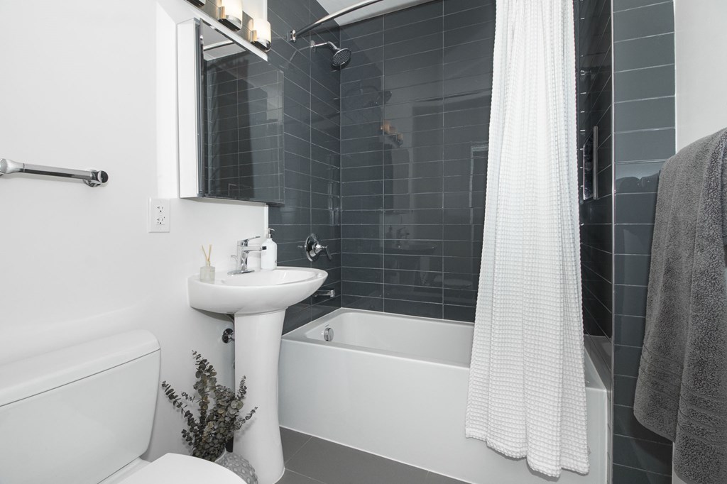A white bathroom with a white sink and a white bathtub.