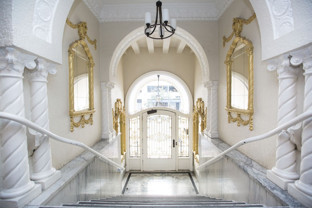 A staircase with a white railing and a chandelier hanging from the ceiling.