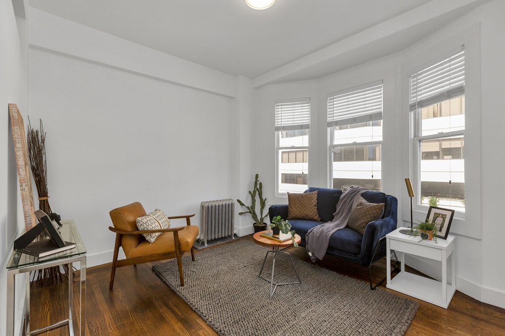 A living room with a blue couch and a brown chair.