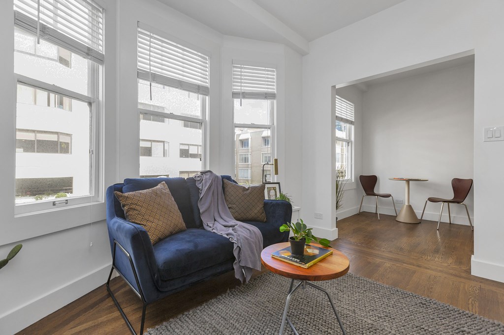 A living room with a blue couch and a wooden coffee table.