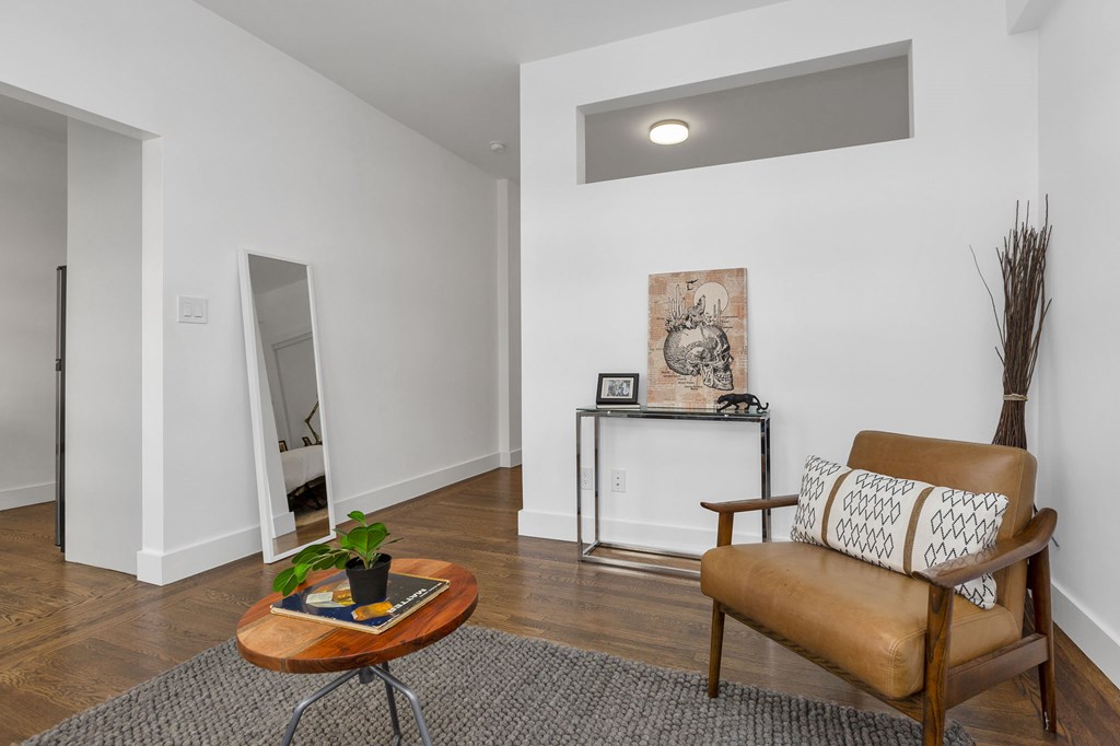 A living room with a brown leather couch, a wooden coffee table, and a framed picture on the wall.