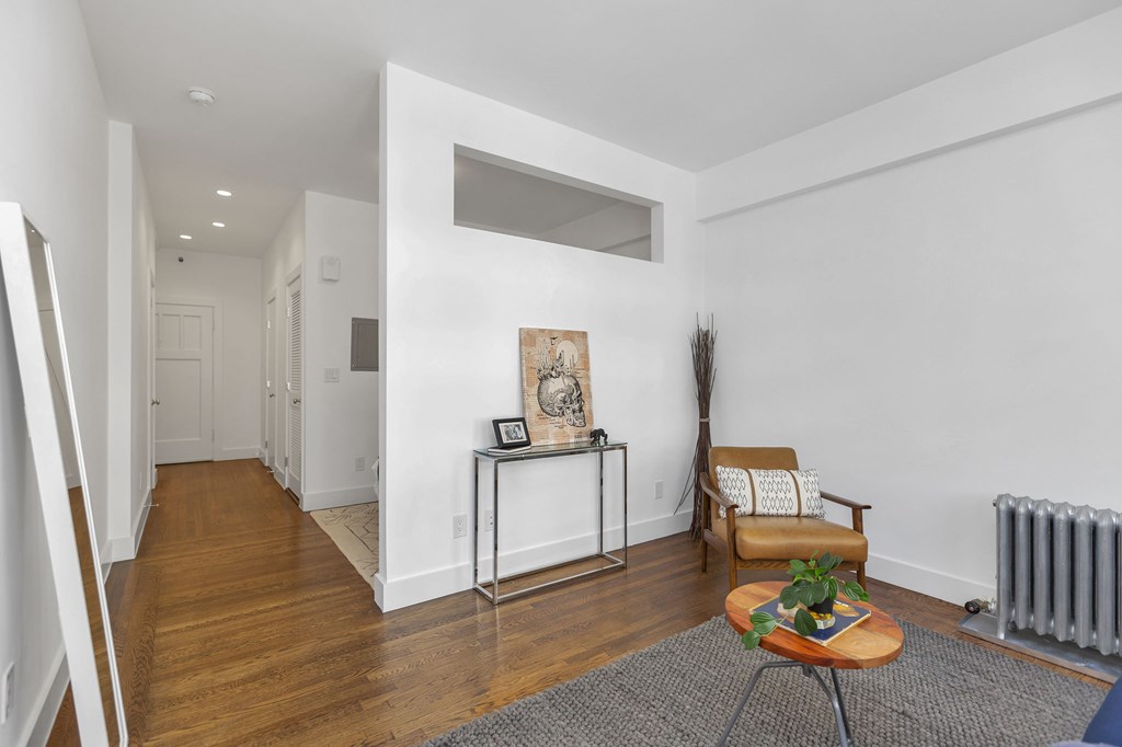 A living room with a brown chair and a small table with a plant on it.