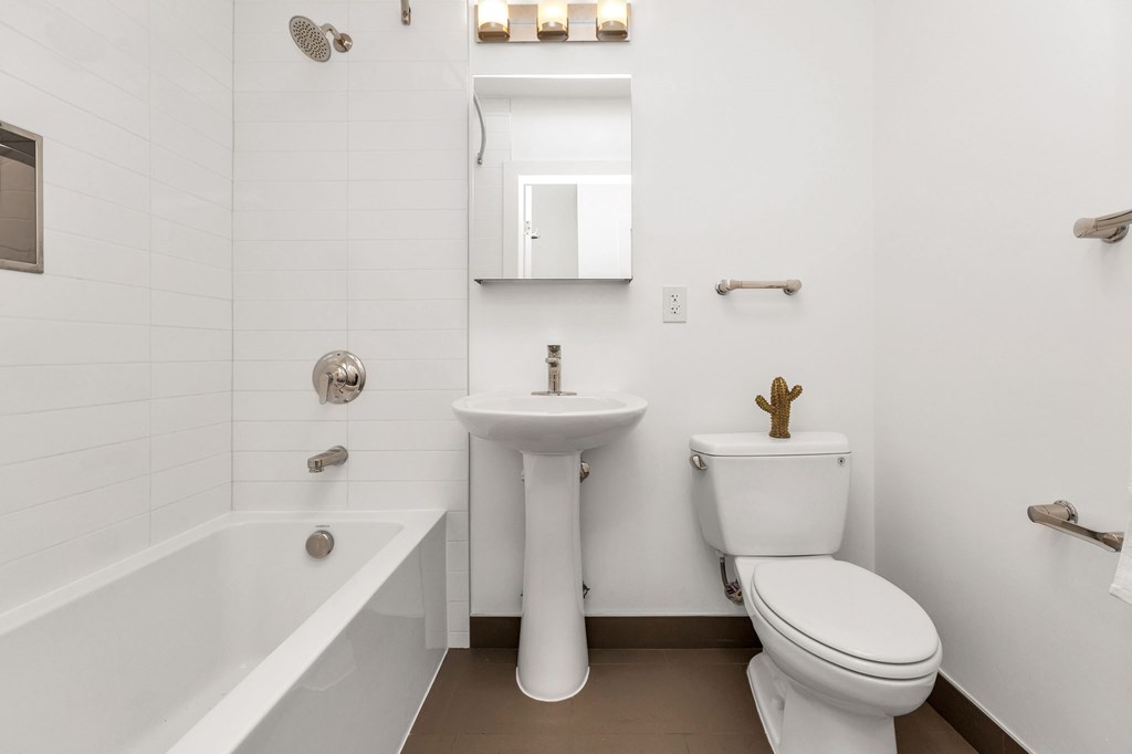 A white bathroom with a toilet, sink, and bathtub.