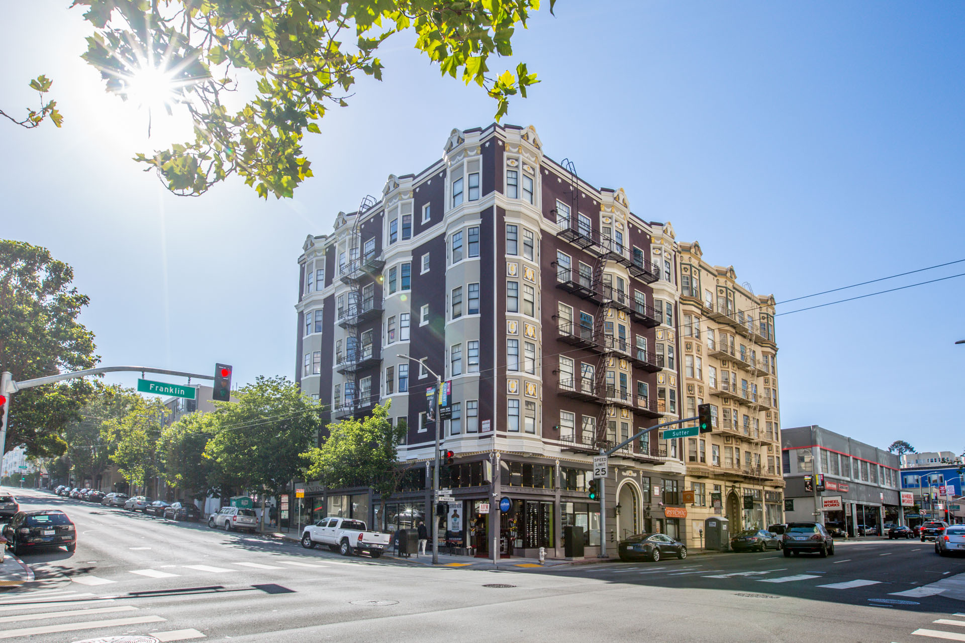 A sunny day in the city with a street view of a multi-story building.
