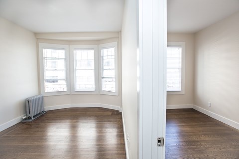 A room with a white door and a radiator on the floor.