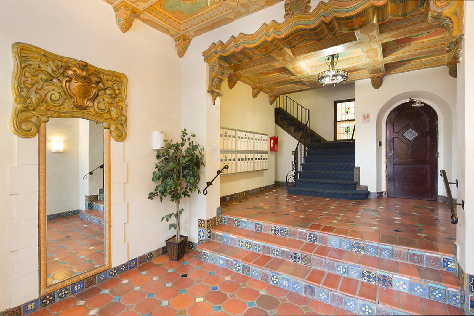 A staircase with a wooden handrail and a plant on the side.