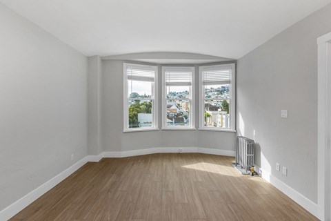 A room with a large window and a radiator on the floor.